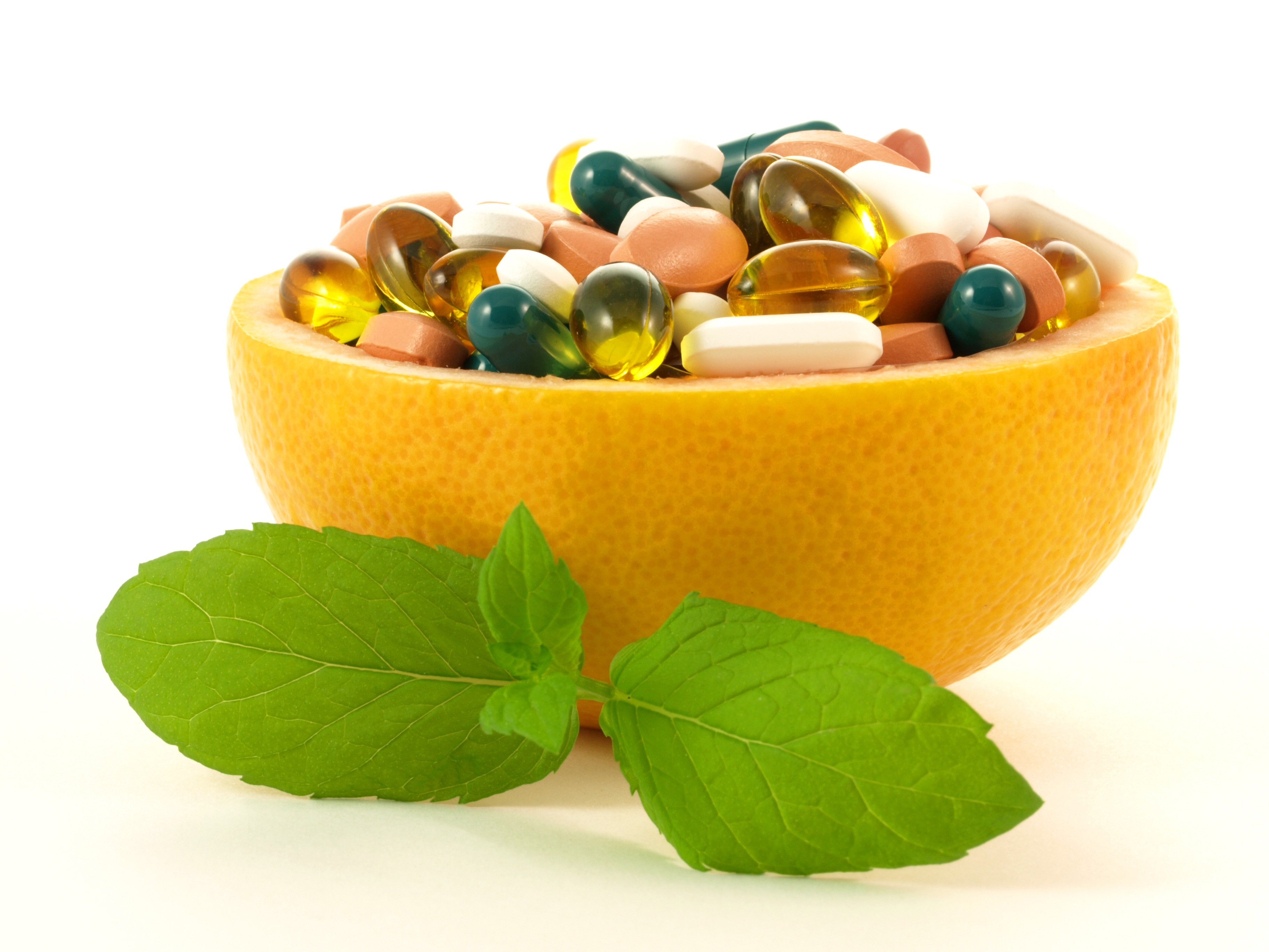 Fruits full of vitamin pills on isolated background.