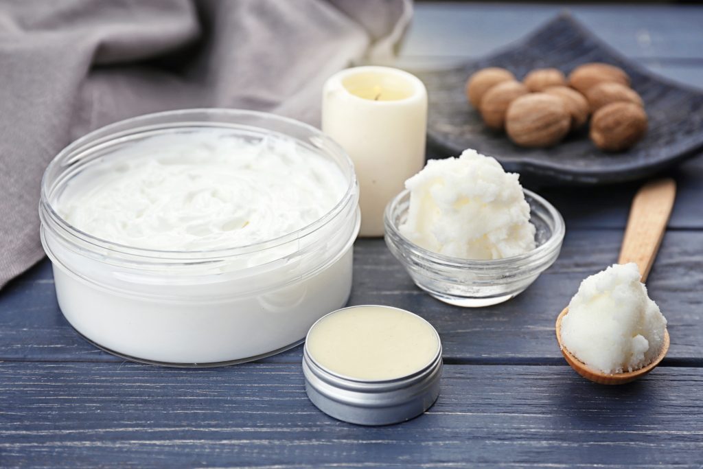 Different cosmetic products with shea butter on wooden table Different cosmetic products with shea butter on wooden table