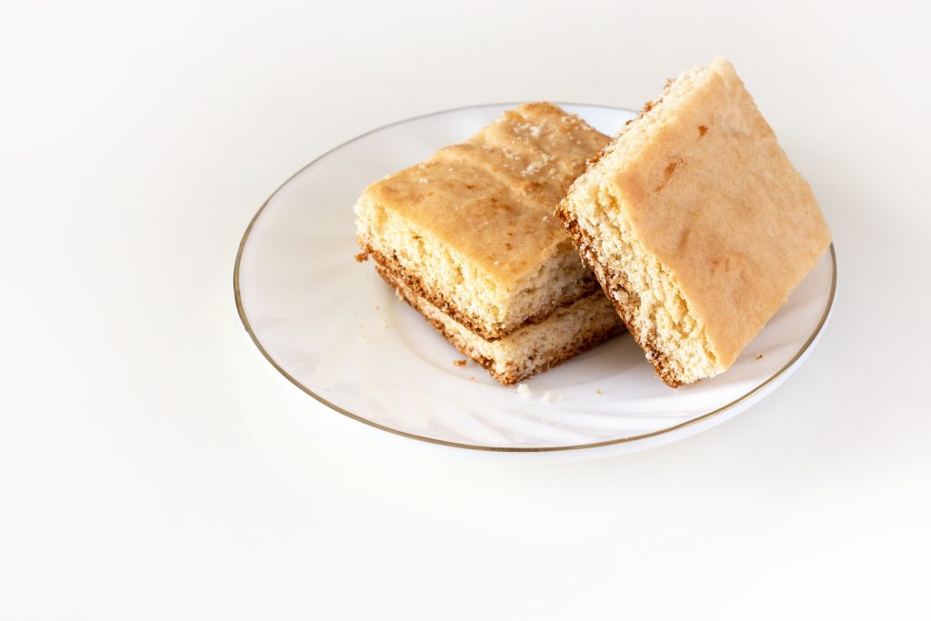 Stack of square pieces lemon cake isolated white background. Selective focus. Stack of square pieces lemon cake isolated white background. Selective focus.